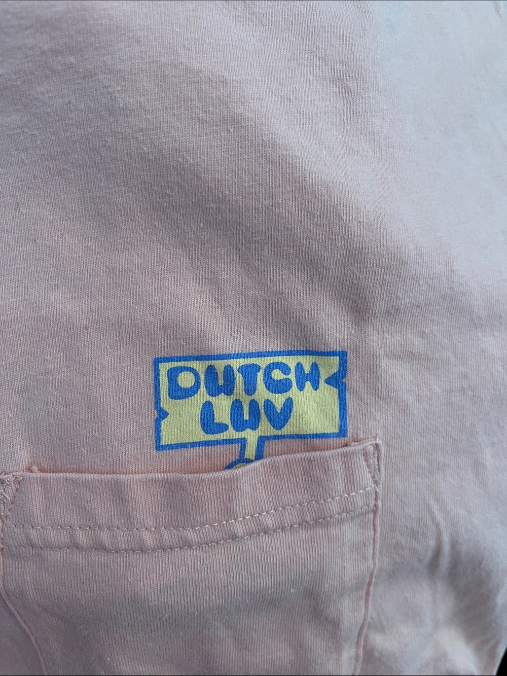 Dutch Bros pink/peach long sleeve tshirt with a front pocket.